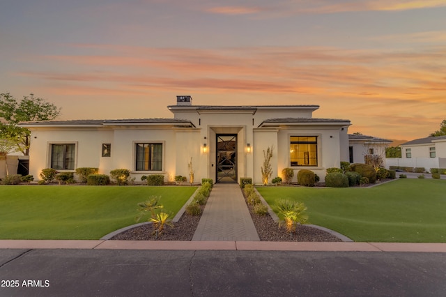 view of front of property with a front yard and stucco siding