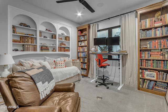 living area featuring carpet floors, built in features, and a ceiling fan