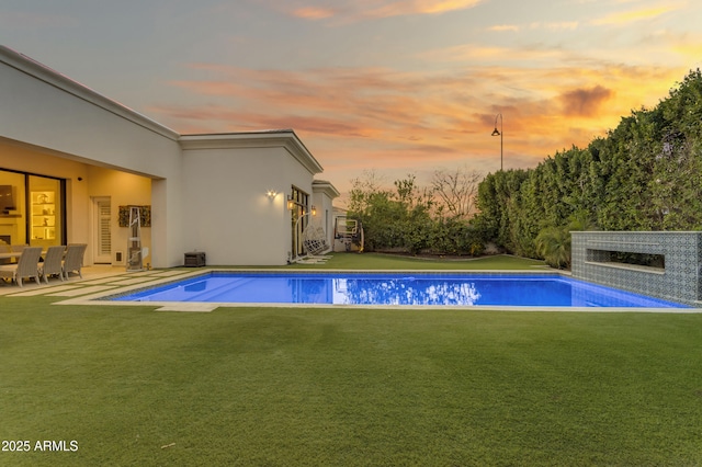 pool with a patio area and a yard