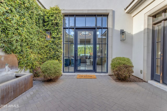 entrance to property with a patio and stucco siding