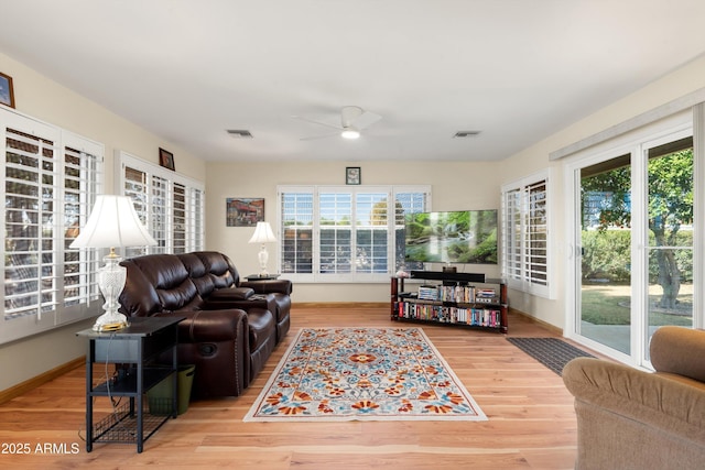 living room featuring a wealth of natural light, visible vents, and wood finished floors