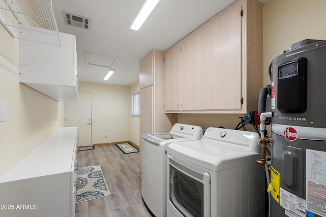 washroom with visible vents, attic access, cabinet space, washing machine and dryer, and light wood-type flooring