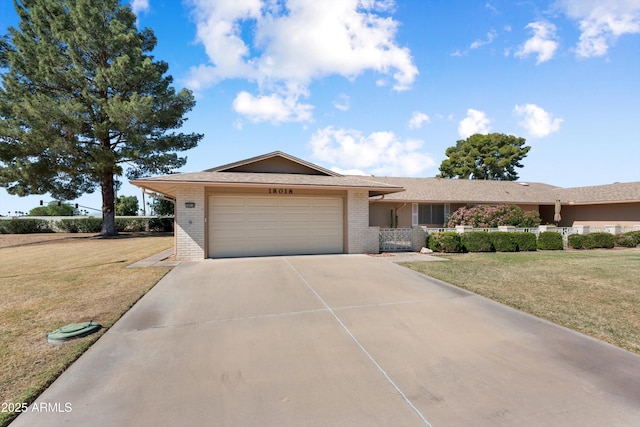 single story home featuring a front lawn, brick siding, a garage, and driveway