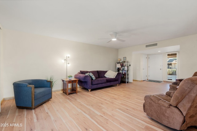 living room with light wood-style flooring, baseboards, and visible vents