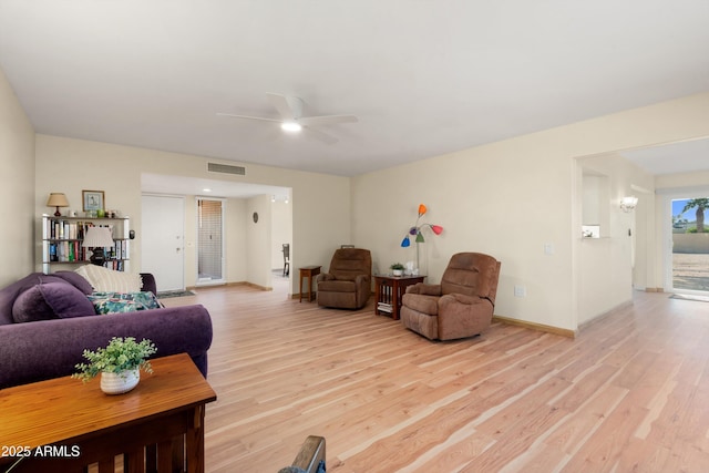 living area featuring visible vents, baseboards, light wood-style floors, and ceiling fan