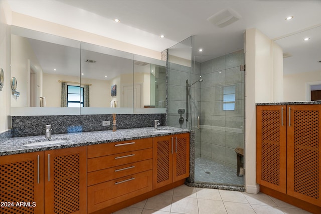 bathroom with tile patterned flooring, vanity, and walk in shower