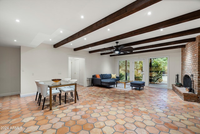 dining area with beam ceiling, a brick fireplace, and ceiling fan