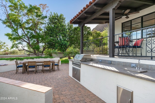 view of patio with a mountain view, grilling area, area for grilling, and ceiling fan