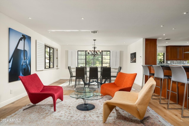 interior space with a wealth of natural light, a chandelier, and light hardwood / wood-style floors