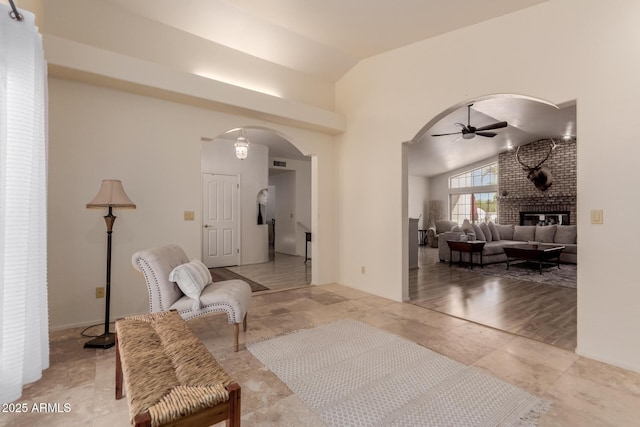 5237 N 106th Ave, Glendale, AZ 85307 - sitting room featuring arched walkways, vaulted ceiling, ceiling fan, and a brick fireplace