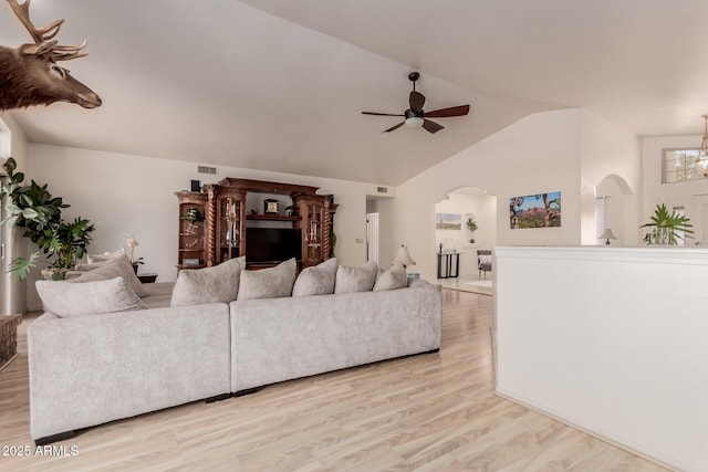 5237 N 106th Ave, Glendale, AZ 85307 - living room with light wood finished floors, arched walkways, lofted ceiling, a ceiling fan, and a chandelier