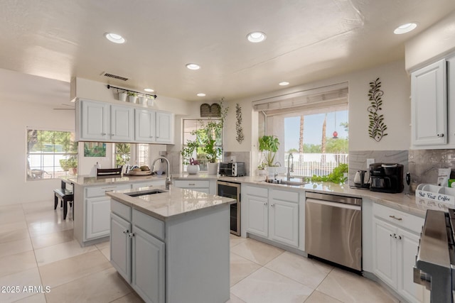5237 N 106th Ave, Glendale, AZ 85307 - kitchen featuring dishwasher, beverage cooler, an island with sink, recessed lighting, and backsplash