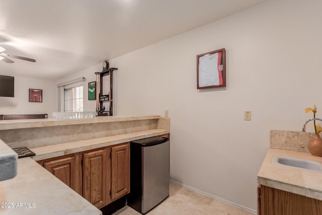 5237 N 106th Ave, Glendale, AZ 85307 - kitchen with stainless steel refrigerator, light countertops, a ceiling fan, and brown cabinetry