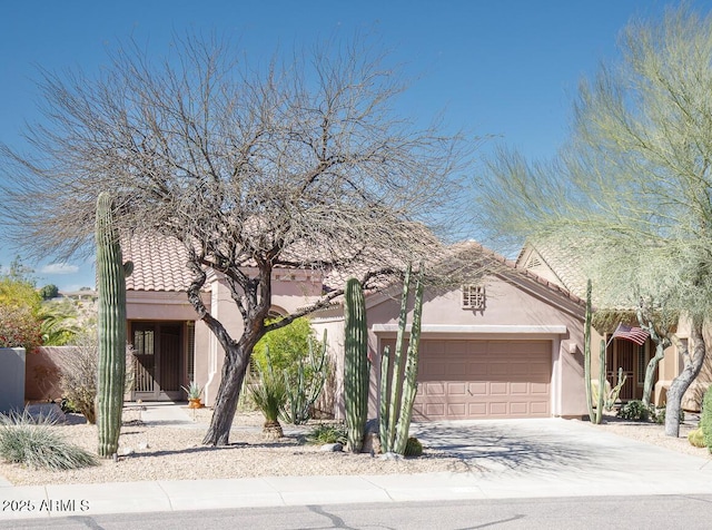 view of front of house featuring a garage, concrete driveway, and stucco siding