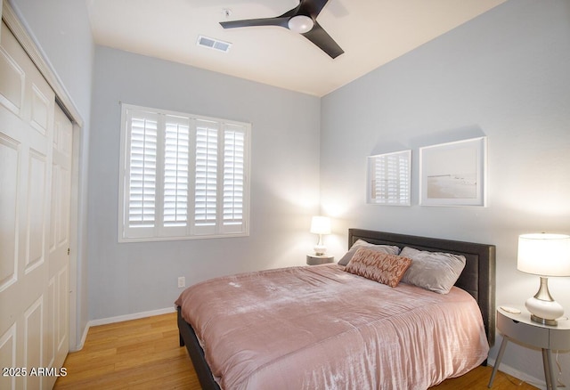 bedroom featuring a closet, visible vents, ceiling fan, light wood-type flooring, and baseboards