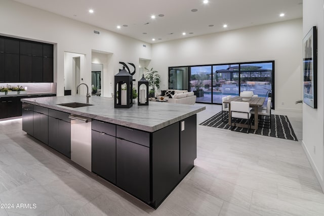 kitchen featuring a spacious island, a towering ceiling, dishwasher, and sink