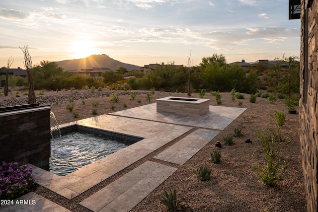 patio terrace at dusk featuring a mountain view