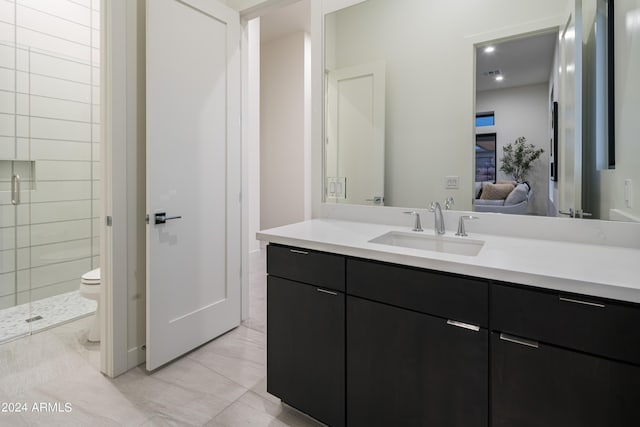 bathroom featuring tile patterned floors, vanity, toilet, and a shower with shower door