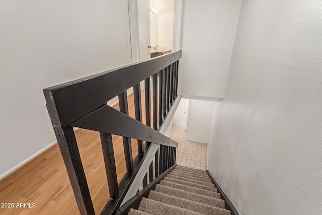 stairs with wood finished floors and baseboards