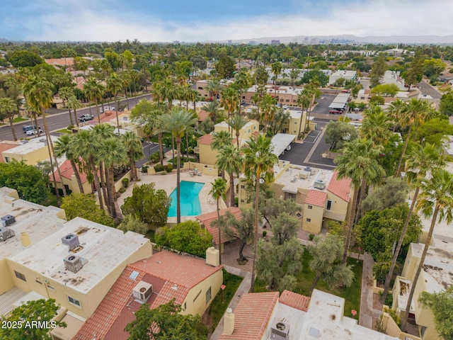 aerial perspective of suburban area featuring a pool area and a mountainous background