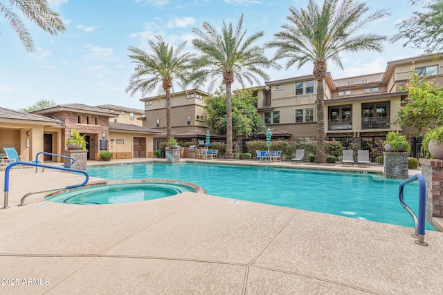 view of swimming pool featuring a patio, fence, and a pool with connected hot tub