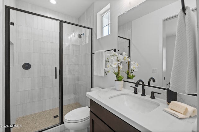 bathroom with walk in shower, vanity, and toilet