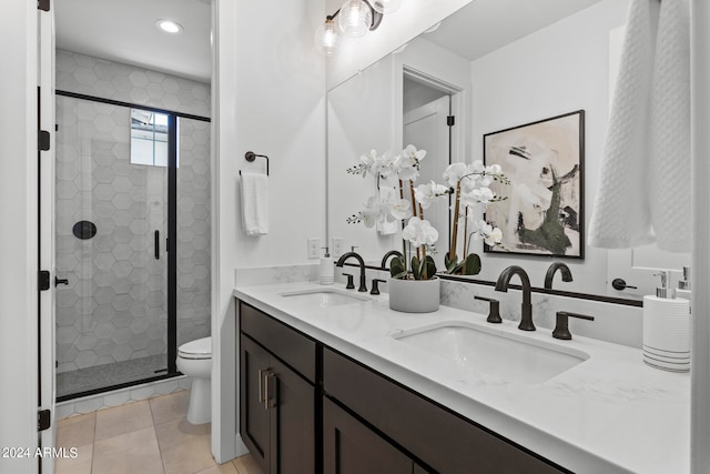 bathroom with vanity, a shower with shower door, toilet, and tile patterned floors