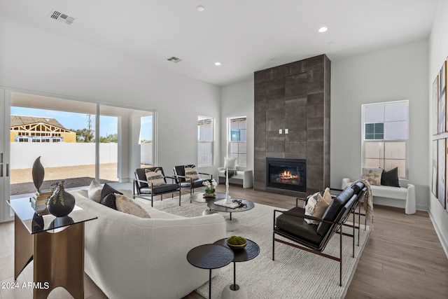 living room with light hardwood / wood-style flooring and a tiled fireplace