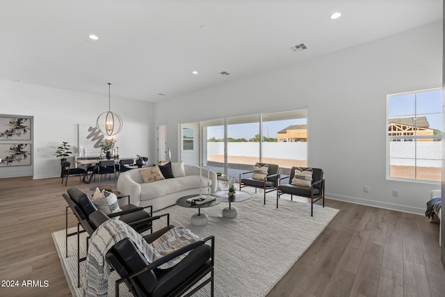 living room featuring wood-type flooring, plenty of natural light, and a chandelier