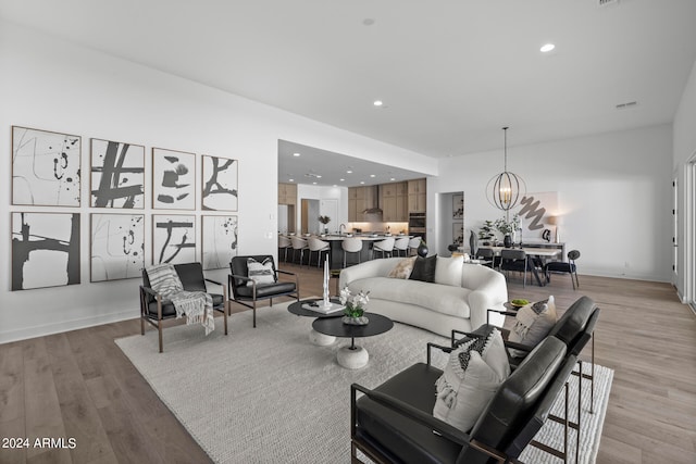 living room with a chandelier and light hardwood / wood-style flooring