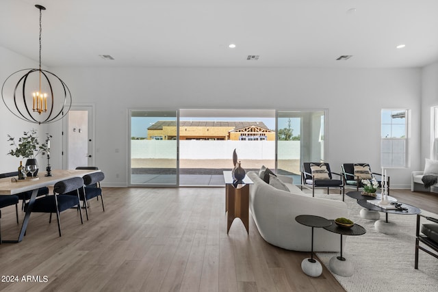 living room with a chandelier and light hardwood / wood-style flooring