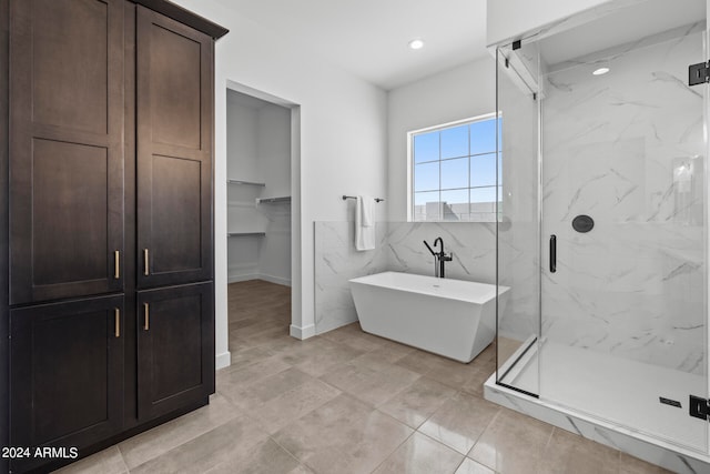 bathroom featuring tile patterned flooring and shower with separate bathtub