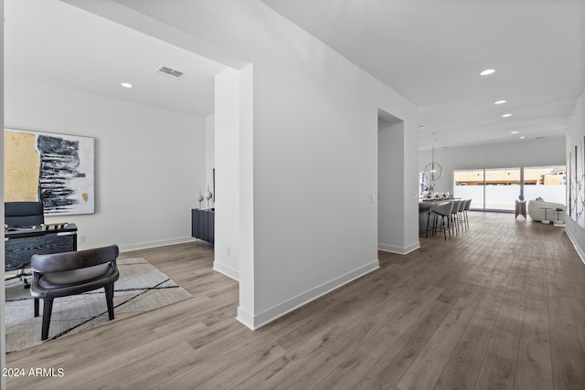 hall featuring a notable chandelier and light hardwood / wood-style floors