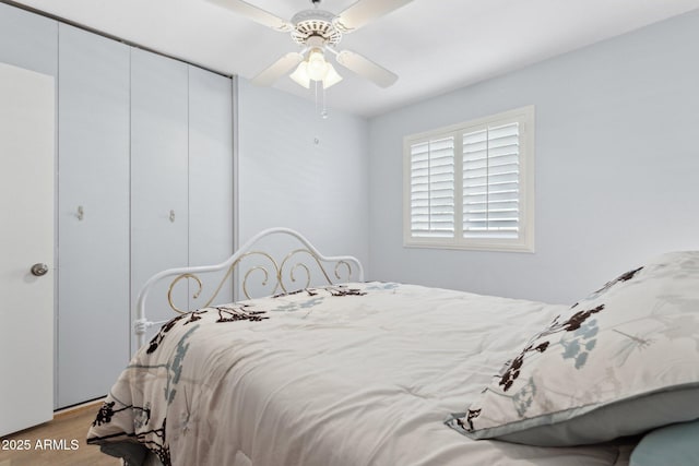 bedroom with ceiling fan, light hardwood / wood-style floors, and a closet