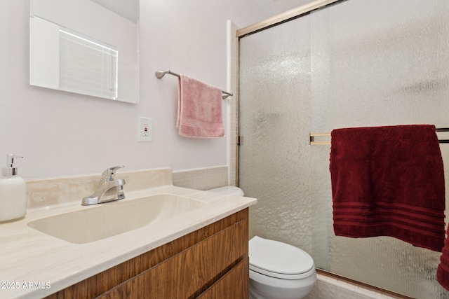 bathroom featuring vanity, walk in shower, and toilet