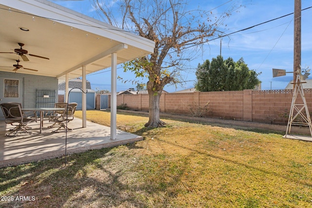 view of yard with a shed, ceiling fan, and a patio area