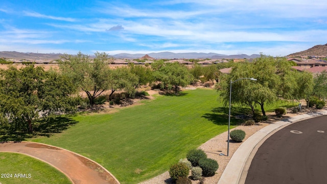 surrounding community featuring a mountain view and a lawn