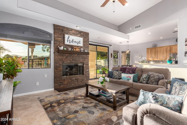 living room with ceiling fan, lofted ceiling, light tile patterned floors, and a wealth of natural light