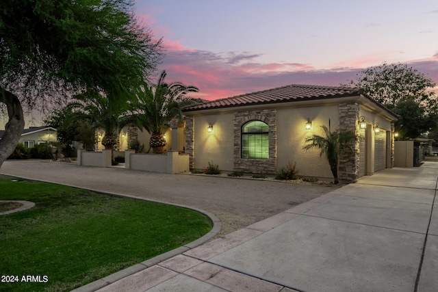 mediterranean / spanish-style house featuring a garage and a yard