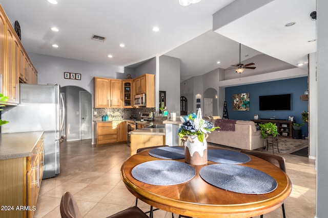 dining space with vaulted ceiling, light tile patterned floors, and ceiling fan