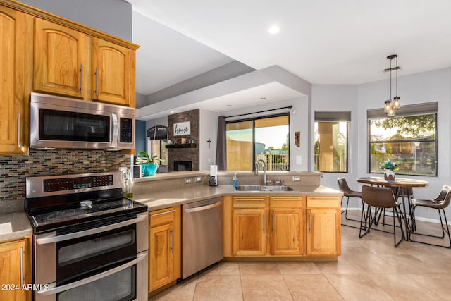 kitchen featuring decorative light fixtures, sink, decorative backsplash, appliances with stainless steel finishes, and light tile patterned floors