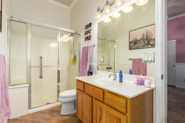 bathroom with vanity, a shower with shower door, toilet, and crown molding