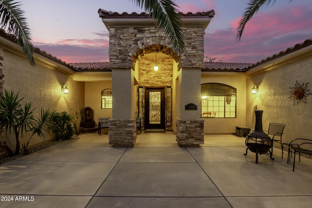 exterior entry at dusk with a patio