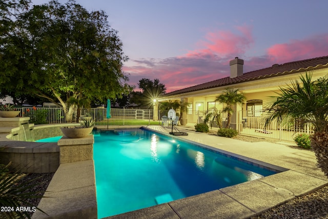 pool at dusk with a patio