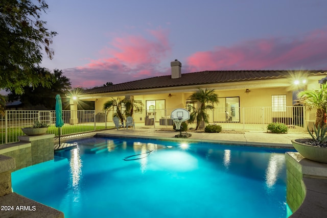 pool at dusk featuring a patio area