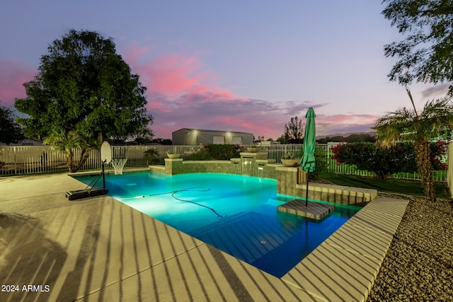 pool at dusk with a patio