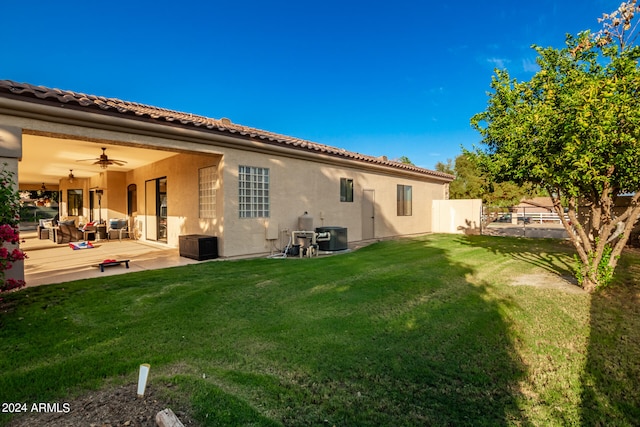 rear view of house featuring a yard, a patio area, and ceiling fan