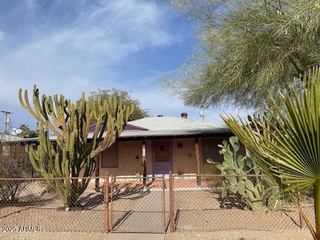 view of front facade featuring fence and stucco siding