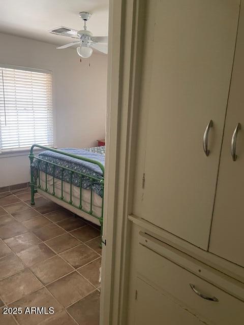 tiled bedroom with visible vents and a ceiling fan