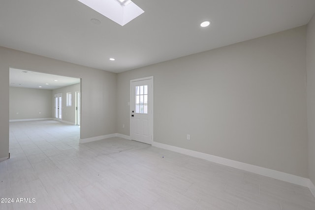 unfurnished room with a skylight